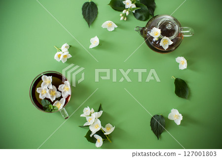 Natural green tea with jasmine petals on the table Natural green tea with jasmine petals on the table 127001803