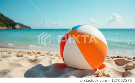 A colorful beach ball on sunny sandy beach. 127002576