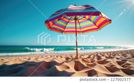 Colorful beach umbrella on a sunny, sandy shore. 127002577