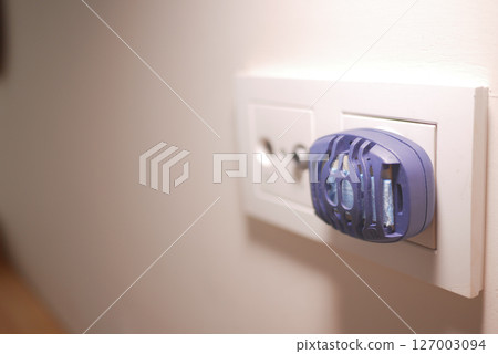 an electric mosquito repellent plugged into a wall socket an electric mosquito repellent plugged into a wall socket 127003094