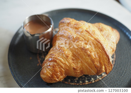 Freshly baked croissant served with hot chocolate drink Freshly baked croissant served with hot chocolate drink 127003100