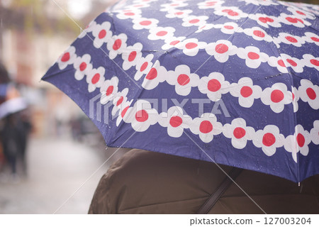 Colorful umbrella brightens rainy city day for pedestrians 127003204