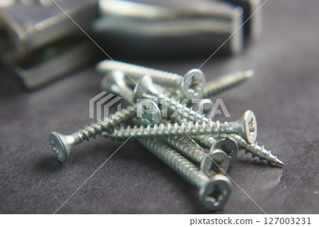 Tools and screws scattered on a workbench for assembly Tools and screws scattered on a workbench for assembly 127003231