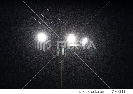 Illumination of heavy rain at night: Raindrops illuminated by street lights Illumination of heavy rain at night: Raindrops illuminated by street lights 127003363