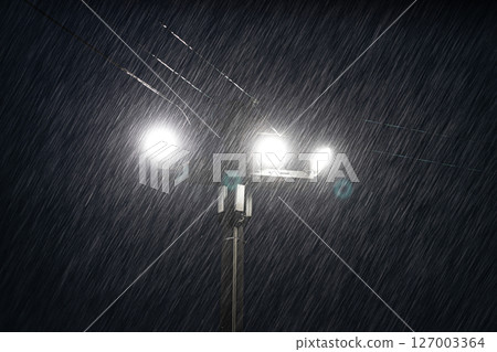 Illumination of heavy rain at night: Raindrops illuminated by street lights Illumination of heavy rain at night: Raindrops illuminated by street lights 127003364