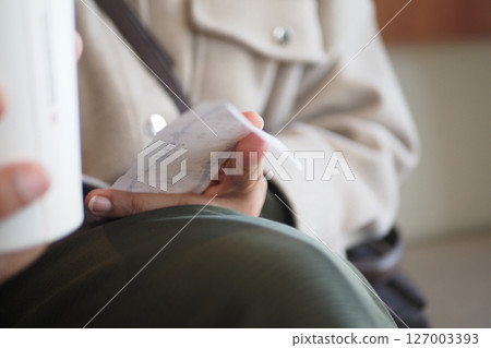 Holding a receipt while drinking coffee at a quiet cafe Holding a receipt while drinking coffee at a quiet cafe 127003393