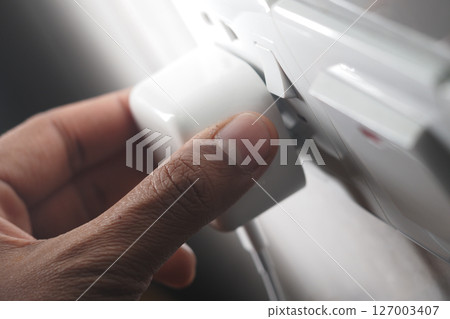 Hand adjusting power plug in modern electrical outlet 127003407