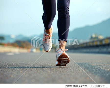 Runners in Active Motion on a Scenic Road During Clear Weather in a Mountainous Area Runners in Active Motion on a Scenic Road During Clear Weather in a Mountainous Area 127003960