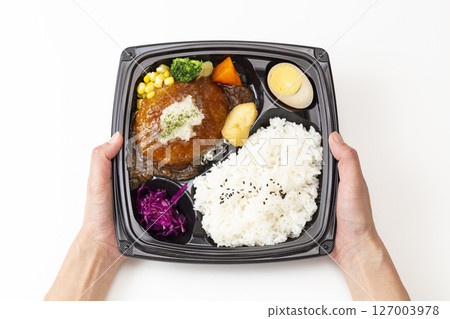 Hand holding a Japanese-style grated hamburger lunch box 127003978
