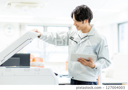 A worker inspecting a printer 127004003