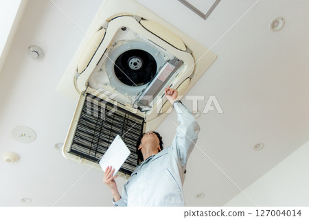 Man repairing the office air conditioner 127004014