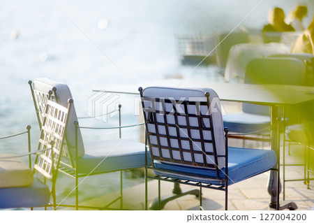 Tables are waiting for visitors or tourists on street in a Mediterranean cafe with national cuisine. The summer veranda of the restaurant near sea 127004200