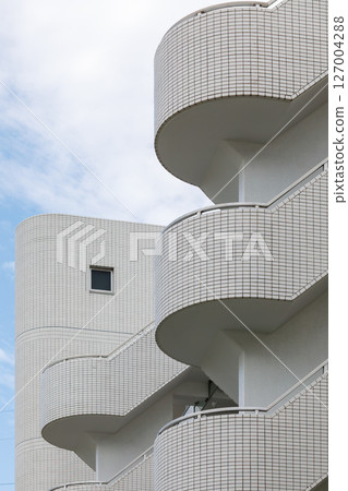 White tiled apartment staircase and small square window 127004288