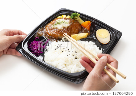 Hands eating a Japanese-style grated hamburger lunch 127004290