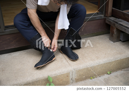 A man working outdoors, such as a gardener, wearing tabi socks in the garden. No face 127005552