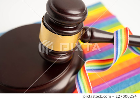 Gavel for judge lawyer on rainbow flag, symbol of LGBT pride month. 127006254