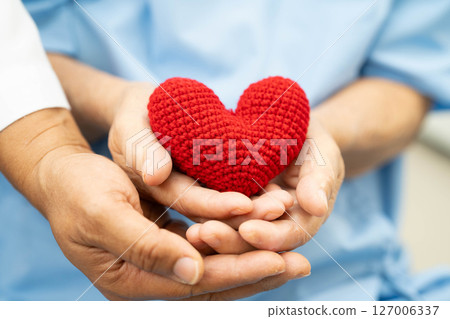 Asian elder senior woman patient holding red heart in hospital. Asian elder senior woman patient holding red heart in hospital. 127006337