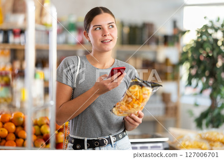 Young woman scanning qr code for snack mix Young woman scanning qr code for snack mix 127006701
