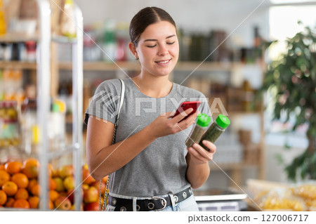 Young woman scanning qr code for spices and seasonings 127006717