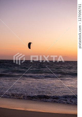 Sunset view of Scarborough Beach in Perth, Australia. with silhouette of a person kitesurfing or skysurfing, surf with a parachute 127006781