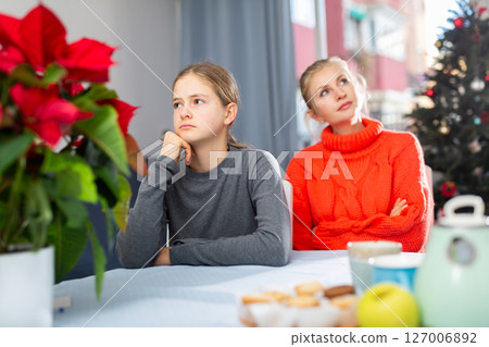 Schoolgirl sitting at the table after quarrel with mother 127006892