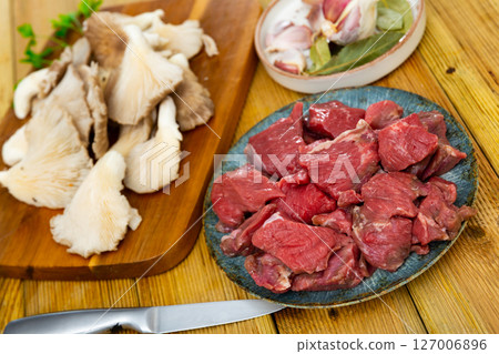 Pieces of raw veal with oyster mushrooms Pieces of raw veal with oyster mushrooms 127006896