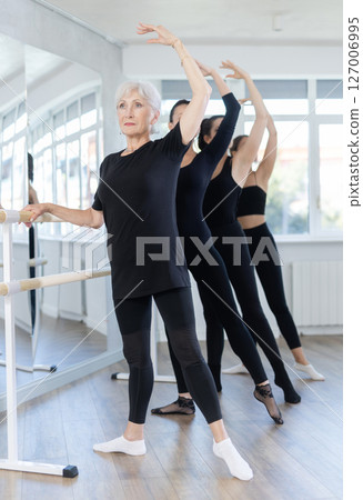 Group of women practicing at ballet barre 127006995