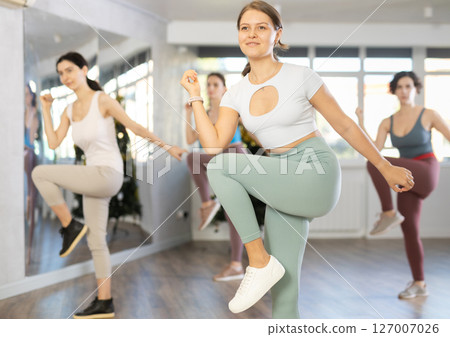 Girl conducts modern dance lessons for group of women during New Year Eve 127007026