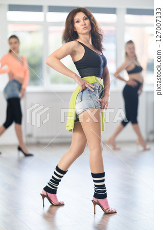 During lesson, woman learn to move and perform dance in heels with women companions 127007133