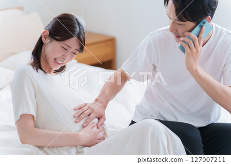 A husband calls the obstetrician-gynecologist when his wife goes into labor A husband calls the obstetrician-gynecologist when his wife goes into labor 127007211
