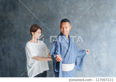 Staff helping foreign tourists put on yukata 127007221