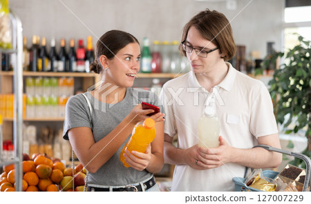 Couple man and woman scanning qr code for soda Couple man and woman scanning qr code for soda 127007229