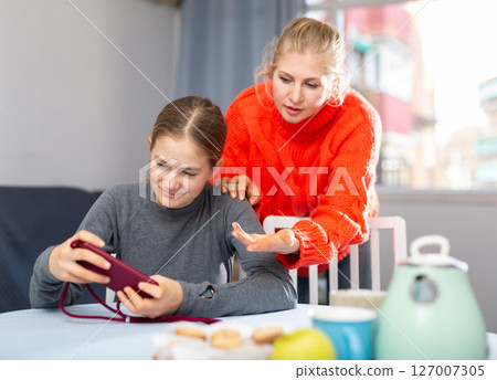 Girl sitting with phone, ignoring mother Girl sitting with phone, ignoring mother 127007305