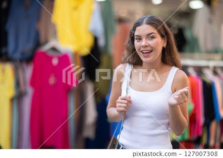 Girl looks at contents of clothes shop window assortment 127007308