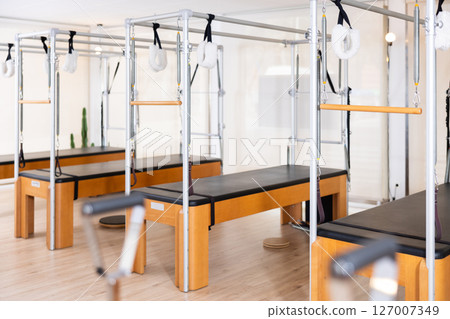 Interior of modern Pilates studio with trapeze tables for exercises 127007349