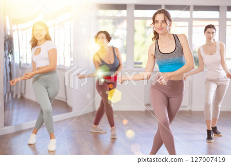 Young female teacher conducts modern hip hop dance lessons for group of girls 127007419