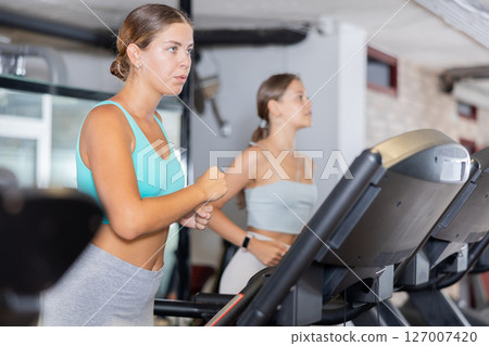 Young woman exercising on treadmill in gym Young woman exercising on treadmill in gym 127007420