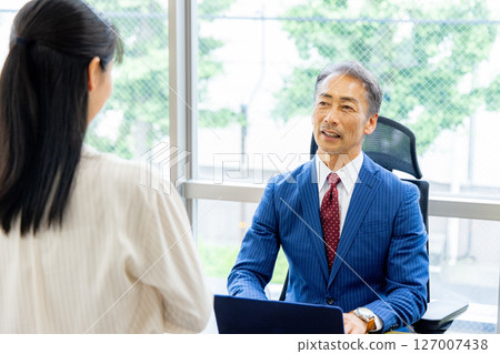 Senior man receiving a report 127007438