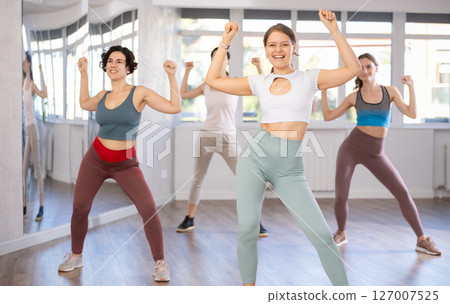 Emotional female dancer rehearsing popping techniques during group workout Emotional female dancer rehearsing popping techniques during group workout 127007525
