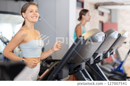 Young woman exercising on treadmill in gym 127007541
