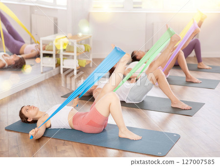 Group of people with working out with rubber bands in gym 127007585