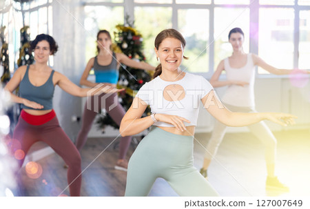 Slender young women dancers dance a swing steps in modern way during the Christmas celebration 127007649