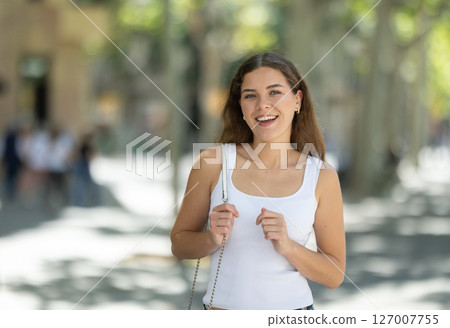 Young woman walking outside on sunny summer day 127007755
