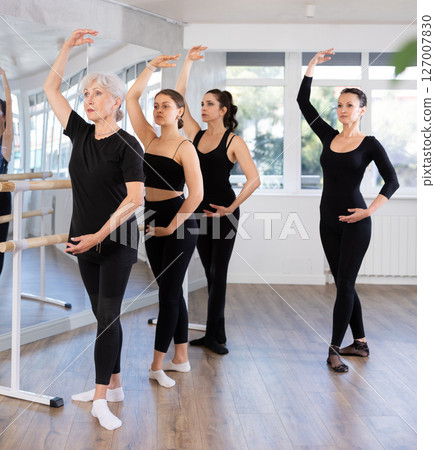 Senior female ballet dancer performing fourth position at training Senior female ballet dancer performing fourth position at training 127007830