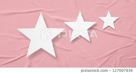 White paper stars, isolated on pink crumpled paper background. White paper stars, isolated on pink crumpled paper background. 127007836