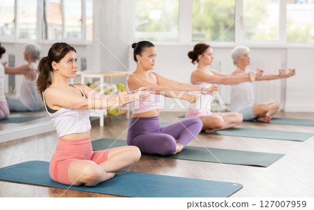 Girl using figure eight resistance band for exercise in pilates class Girl using figure eight resistance band for exercise in pilates class 127007959