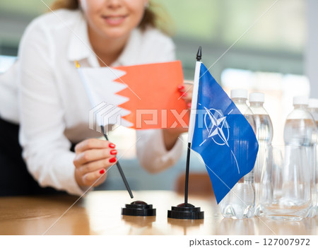 Young female secretary preparing room for international negotiations between nato and bahrain 127007972