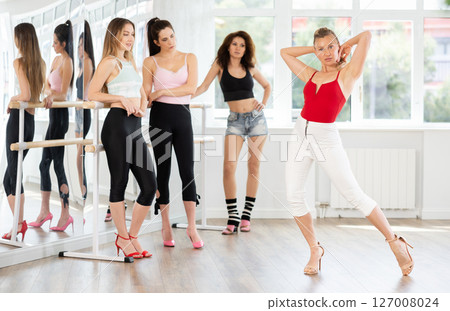 Adult woman shows high heels dance to group 127008024