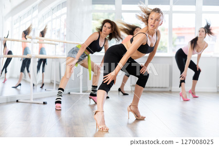 During lesson, woman learn to move and perform dance in heels with women companions 127008025