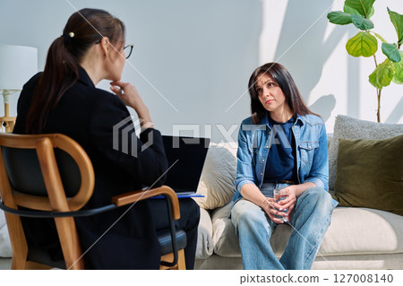 Young woman patient at mental therapy session, talking with psychologist Young woman patient at mental therapy session, talking with psychologist 127008140